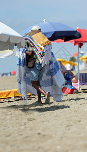 小摊贩夏天在沙滩上卖毛巾背景