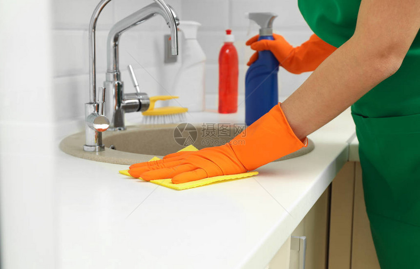 身着防护手套的妇女清洁厨房水槽图片