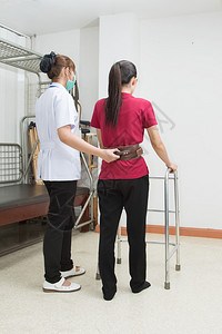 物理治疗师帮助病人在医院使用助行器走图片