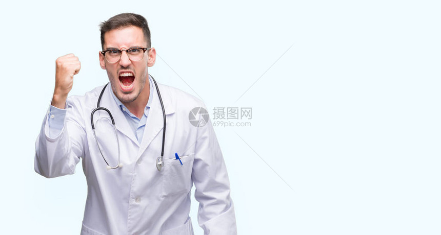 怒气勃的年轻医生男子愤怒和疯狂地举起拳头感到沮丧和愤怒图片