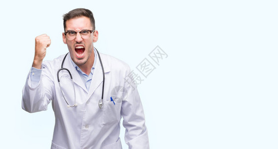 怒气勃的年轻医生男子愤怒和疯狂地举起拳头感到沮丧和愤怒图片