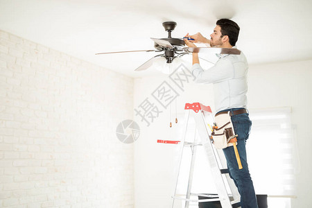 男电动踩梯和在房屋安装天花板风图片