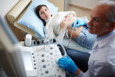 孕妇在定期检查时看超声设备屏幕图片
