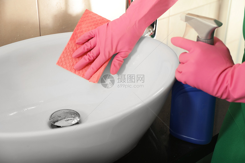戴防护手套的妇女清洁洗手间水槽图片
