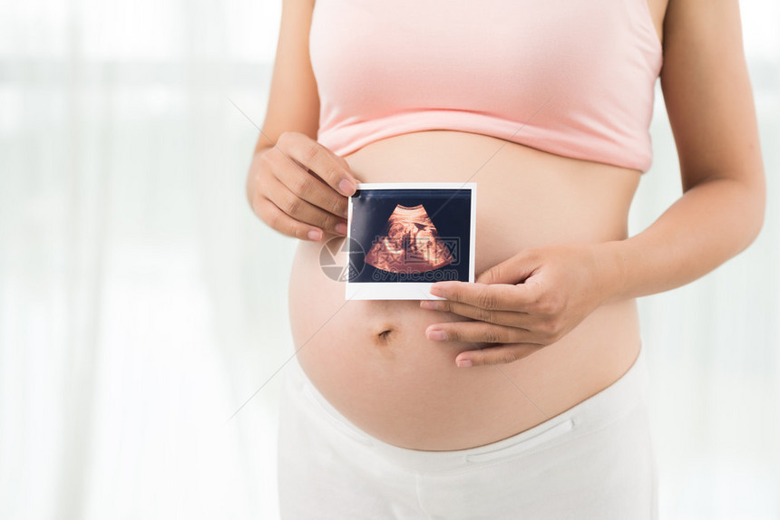 孕妇的裁剪图像显示婴儿图片