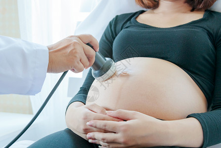 医生在孕妇肚子上移动超声波图片