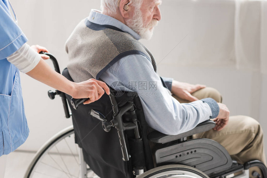 护士站在轮椅残疾老年男子身后图片