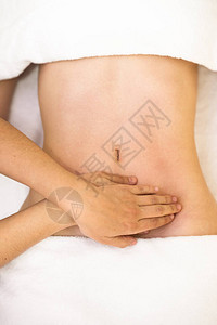 手按摩女腹部的顶端视图对腹部图片
