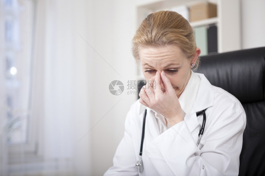 坐在办公室的有近身压力的成年女医生图片