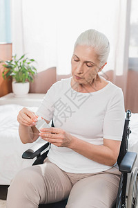 使用药品用集装箱的轮椅残疾老年残疾妇女图片