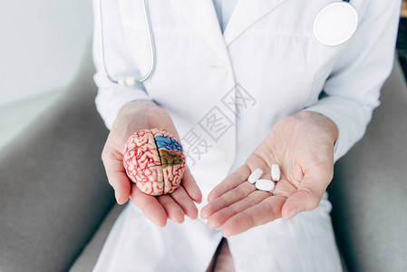 医生持有大脑和药丸模式图片