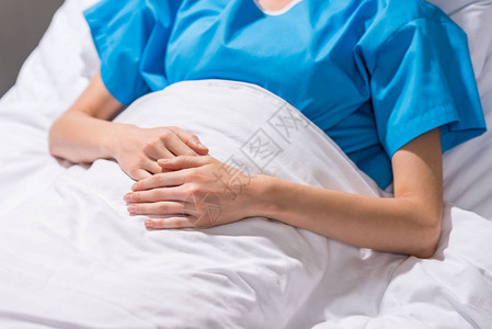 生病妇女躺在医院床图片