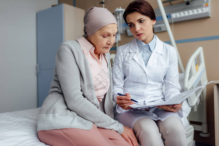 接受诊断和咨询在医院患有癌症的高级女患者的女图片