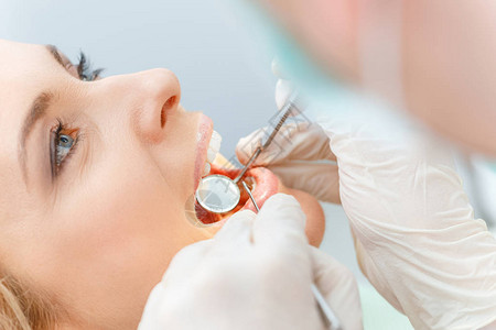 在牙科检查时对美貌中年女进行近图片