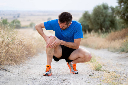 在肌肉或韧带损伤概念的柏油路上进行跑步锻炼训练期间肌肉受伤后背景图片