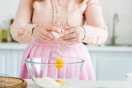 妇女在用面粉在碗里加蛋和面图片