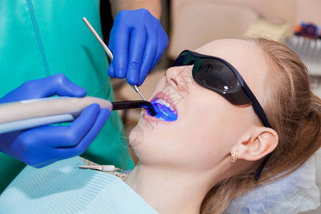 牙医在病人牙齿上使用图片