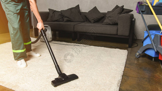 在清洗白地毯时使用真空清洁器的局部视线图片