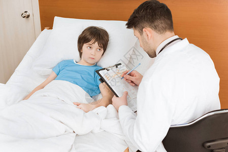 医生记录儿童病人在医院的症状并写下图片