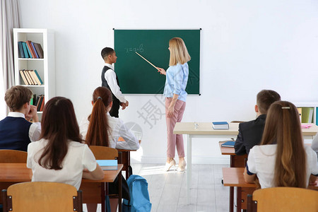 教室黑板上的女老师和小学生图片