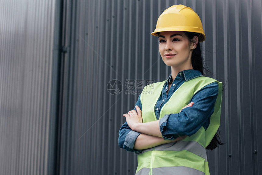 佩戴安全背心和安全背心和头盔的自信女建筑师图片