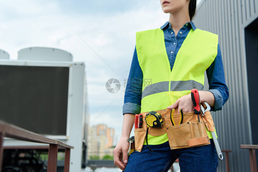 安全背心上带工具带的女工图片