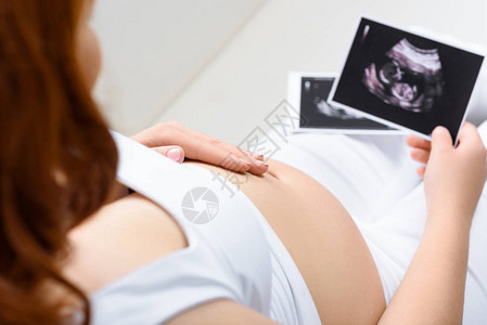 孕妇触摸肚子并在家里进行超声波扫描图片
