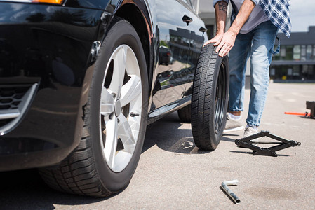 人动新轮胎和修理破旧汽车汽车保险概念的图片