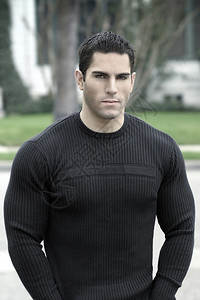 户外穿黑色衬衫的年轻肌肉男的肖像图片