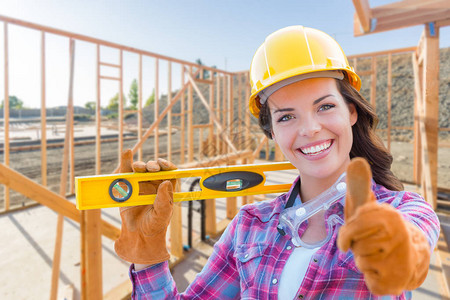 在建筑工地戴手套安全帽和护目镜的女建筑工图片
