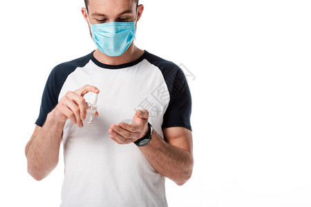 男子身戴医疗面具用喷雾瓶装抗菌液贴图片