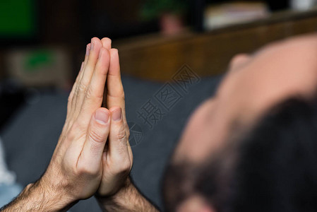 独自一人坐在家中时握着祈祷手的孤独男图片