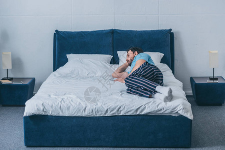 孤单的孤独男人躺在家里床上图片