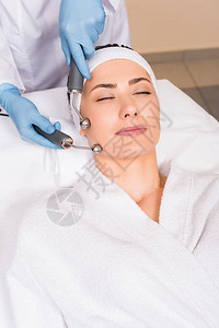 美容师在美容院用设备在女人脸上做提升图片