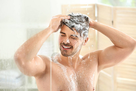 英俊的男人在家洗头发图片
