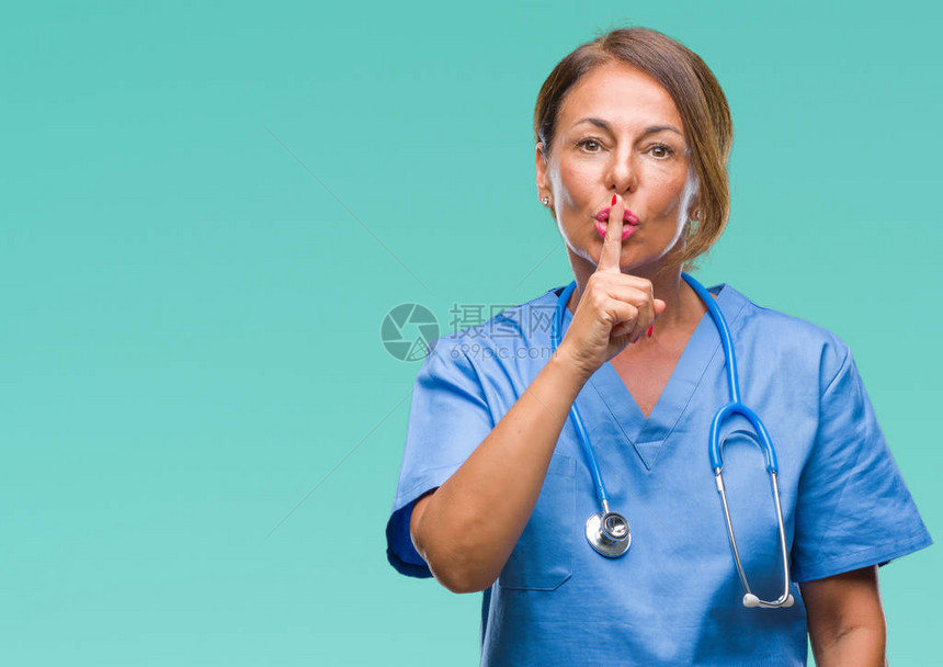身处孤立背景的中年高级护士女医生要求用手指嘴唇保持安静图片
