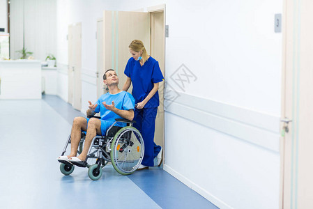 外科医生在医院走廊与坐在轮椅上的图片