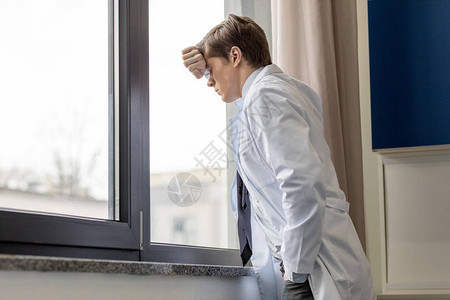 站在医院窗户边思考的医生护理医生概念图片