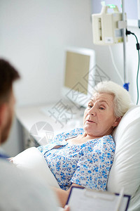 老年妇女在与医生交谈时躺在医院床图片
