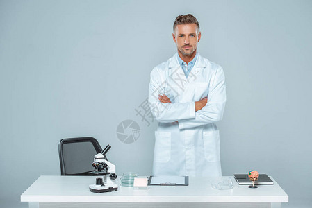 长相英俊的科学家站着与交叉手图片