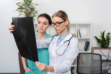 眼镜和护士检查医院X光照片的重图片