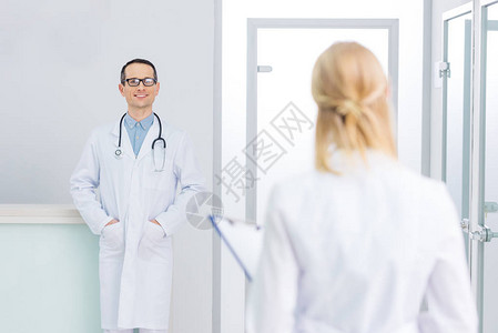 男医生穿白色大衣有听诊器在诊图片