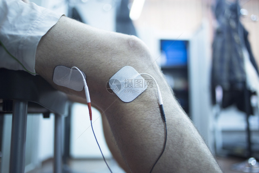 患者膝盖腿大腿和小腿在物理治疗电脉冲刺激康复治疗在医院诊所用电刺激附图片