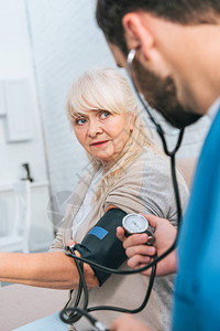 社会工作者对老年妇女测量血压图片