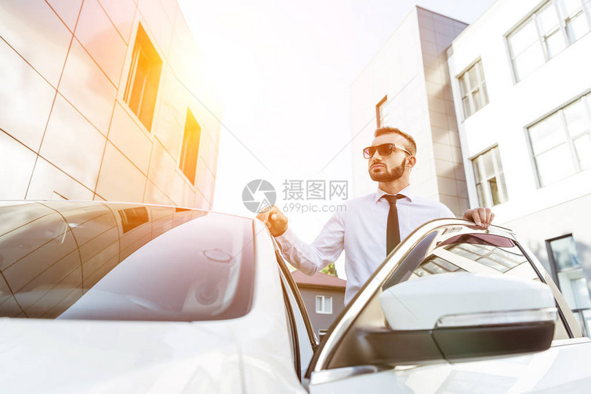日落时身戴太阳镜的帅司机站在街上开图片