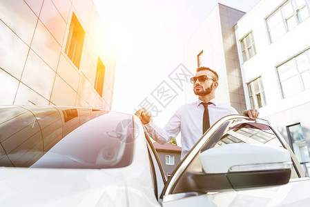 日落时身戴太阳镜的帅司机站在街上开图片