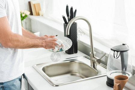 男人早上在厨房洗碗的剪影图片