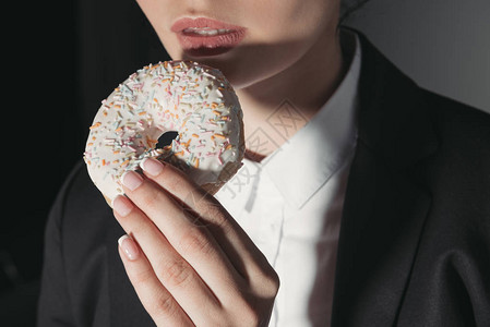女人吃甜圈的剪影图片
