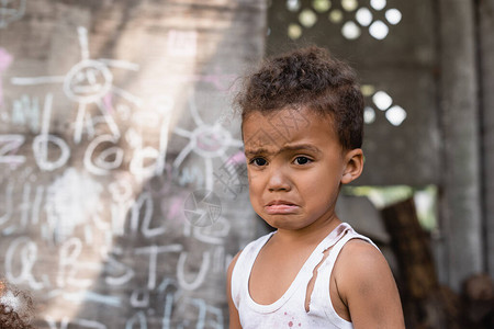 贫穷的非裔美国男孩在黑板附近哭泣时图片