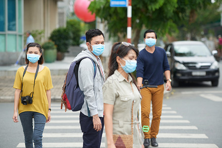 由于空气污染亚洲城市居民在户外冒着图片